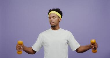 A man is holding two dumbbells in his hands video