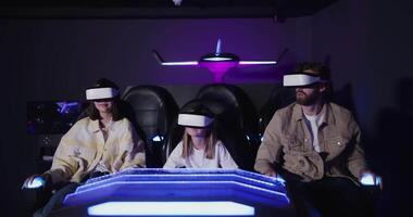 Three people wearing virtual reality glasses in a dark room video
