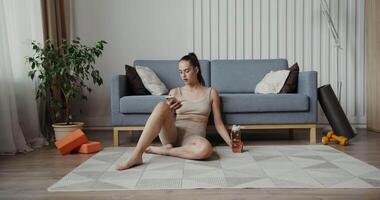 A woman sitting on the floor with a phone video