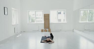 A woman is doing a yoga pose in an empty room video