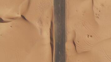 A road in the desert with sand dunes in the background video