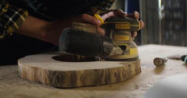 A man is using a drill to make a hole in a piece of wood video