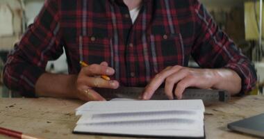 A man is writing on a notebook with a pencil video