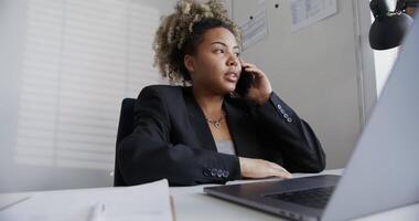 A woman in a business suit talking on the phone video