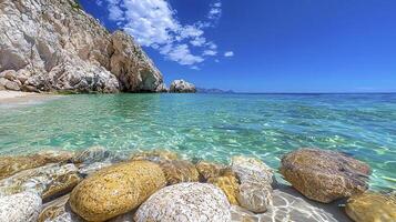 A beach with rocks and water in front of a cliff photo