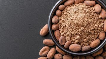 Chocolate powder in a bowl and cocoa beans on a black background photo