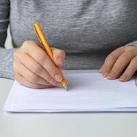 A person writing on a piece of paper photo