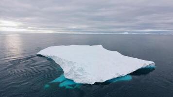 A breathtaking aerial view showcasing an enormous iceberg floating effortlessly in the vast ocean video
