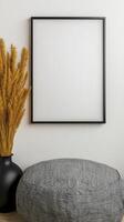 Mock up frame mock up frame on a white wall with a grey cushion and a vase photo