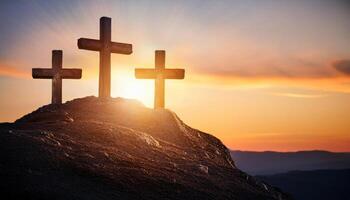 Three Crosses stand on hill. Sunrise glow lights the sky. Easter morning with religious symbol. Faith and hope with the cross at dawn. photo