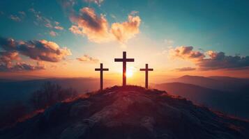 Three crosses stand on a hill. Sunset shines behind the crosses. Sky has colorful clouds. Christian faith and Easter concept. photo