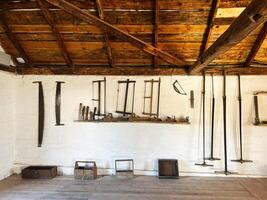 Vintage woodworking tools displayed on a wall in a rustic workshop photo
