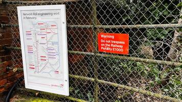 Warning and network rail signage on a chain link fence in Enfield, London photo