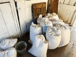 White sacks of stored grain inside a rustic wooden barn with natural light photo