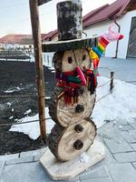 Outdoor rustic snowman decoration crafted from wooden logs in a winter setting photo