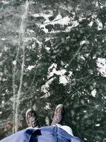 Person standing on a natural frozen lake with visible ice cracks and snow photo