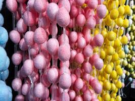 Colorful Decorative Pom Pom Strings in Pink, Yellow, and Blue on Display photo
