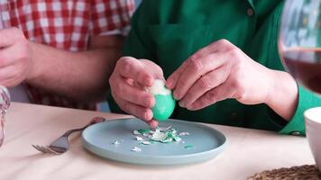 man and woman removing eggshells from Easter painted eggs video