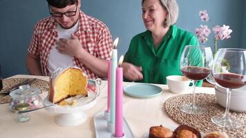 man and woman eating Easter cake and drinking coffee on dinner table at home video