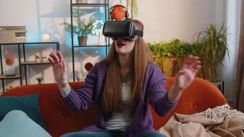 Woman using virtual reality futuristic technology headset to play simulation 3D game at home video