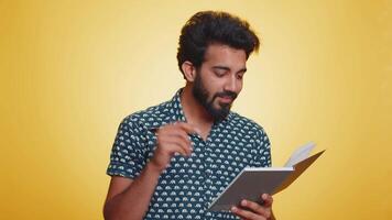 Man making notes, writing down thoughts with pen into notepad notebook diary, to do list, good idea video
