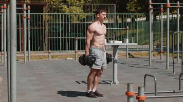 Athletic caucasian muscular man doing exercises with weight, squatting with dumbbells in hands video