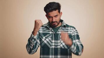 Aggressive indian man trying to fight at camera, shaking fist, boxing with expression, punishment video