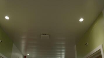 View of a hospital corridor ceiling with lights and a smoke detector, as seen from the perspective of a patient being transported on a stretcher video