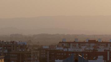 Sunlight illuminating a hazy cityscape creates a warm atmosphere during the enchanting golden hour of the evening video