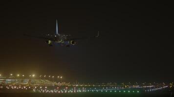 Airplane landing on a runway at night, surrounded by illuminated cityscape and dark skies, creates a captivating scene video