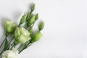 Fresh green colors on a natural stone table, white marble background with copy space, flat lay, photo