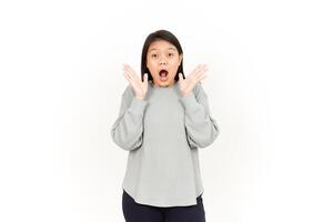 A woman is making a surprised face while standing in front of a white background photo
