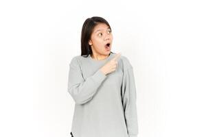 A woman is pointing to her mouth while wearing a grey sweatshirt photo