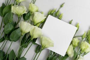 Real photo. square invitation card mockup with a eustoma flowers. Top view with copy space, light gray photo