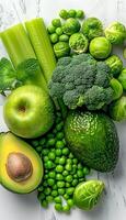 Assorted green fruits and vegetables displayed on a table photo