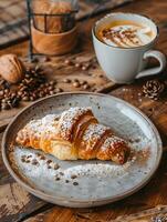 Croissant with powdered sugar on a plate, served with a cup of Cuban espresso photo