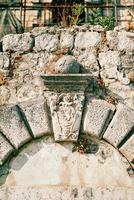 Carved coat of arms on a keystone on an old stone wall photo