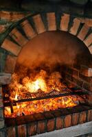 Ribs are grilled on a grid on a fire in a brick oven photo
