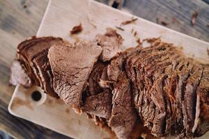 Slices of juicy roast beef lie in a row on a cutting board photo