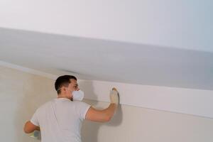 Disinfector washes the walls under the ceiling with a sponge photo