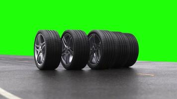 Loop four car wheels rolling on wet asphalt on a green background video