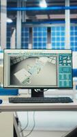 Vertical PC on desk in empty photovoltaics factory monitoring system performance. Computer monitor in sustainable solar panels manufacturing plant tracking energy production and efficiency video