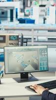 Vertical Photovoltaics factory worker drinks coffee, monitoring performance of robot arms placing solar panels on assembly lines. Man enjoys beverage at computer desk, inspecting solar plant machines, camera A video