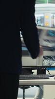 Vertical Photovoltaics factory engineer using software on laptop to improve solar panels efficiency. Solar panels manufacturing plant employee researching sustainable solar solutions using notebook, camera B video