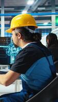 Vertical Photovoltaics factory engineer uses artificial intelligence to diagnose malfunctioning systems. Solar panel manufacturing plant worker uses AI tech to maintain system operational reliability, camera A video