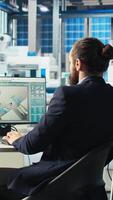 Vertical Photovoltaics factory engineer drinking coffee analyzing data, reviewing system metrics. Solar panels plant technician enjoying beverage troubleshooting technical issues using computer video