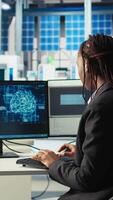 Vertical Software developer in photovoltaics factory using artificial intelligence to oversee robot arms placing solar panels on assembly lines. System administrator upgrading solar plant using AI, camera A video