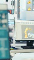 Vertical PC on desk in empty photovoltaics factory monitoring system performance. Computer monitor in sustainable solar panels manufacturing plant tracking energy production and efficiency, close up video