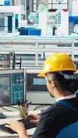 Vertical Manager instructs solar panels plant employee on how to use CAD software to optimize layouts. Photovoltaics factory supervisor teaches worker how to do arrangements for maximum energy output, camera A video