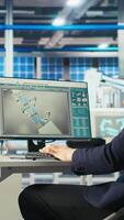 Vertical Photovoltaics factory engineer looking over paperwork documents, analyzing data. Solar panels manufacturing plant employee reading documentation files, troubleshooting technical issues, camera A video